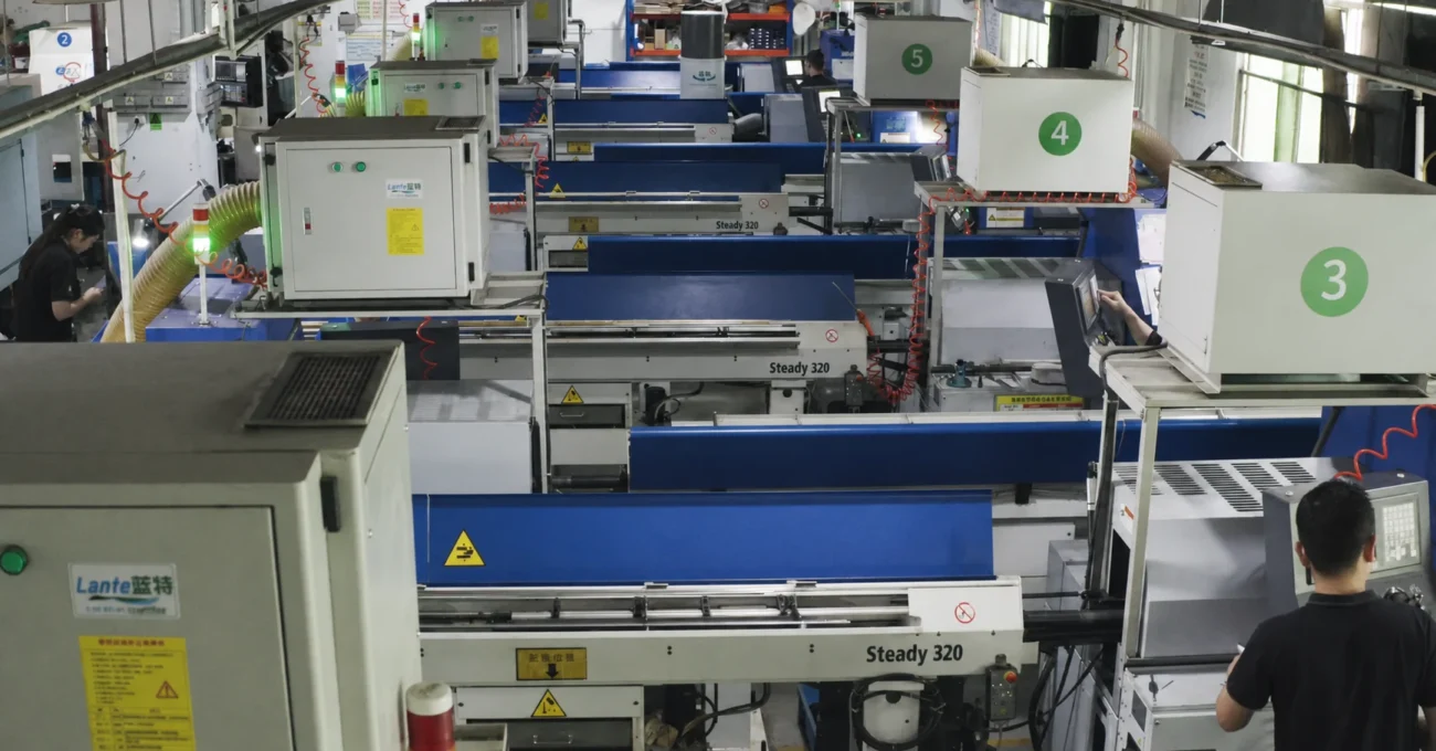 Mill-turn machining center workshop with workers in black uniforms operating CNC machines