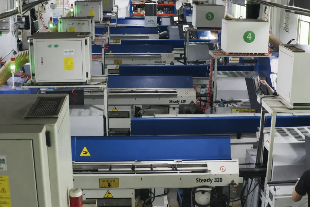 Swiss machining center workshop with workers in black uniforms operating CNC machines